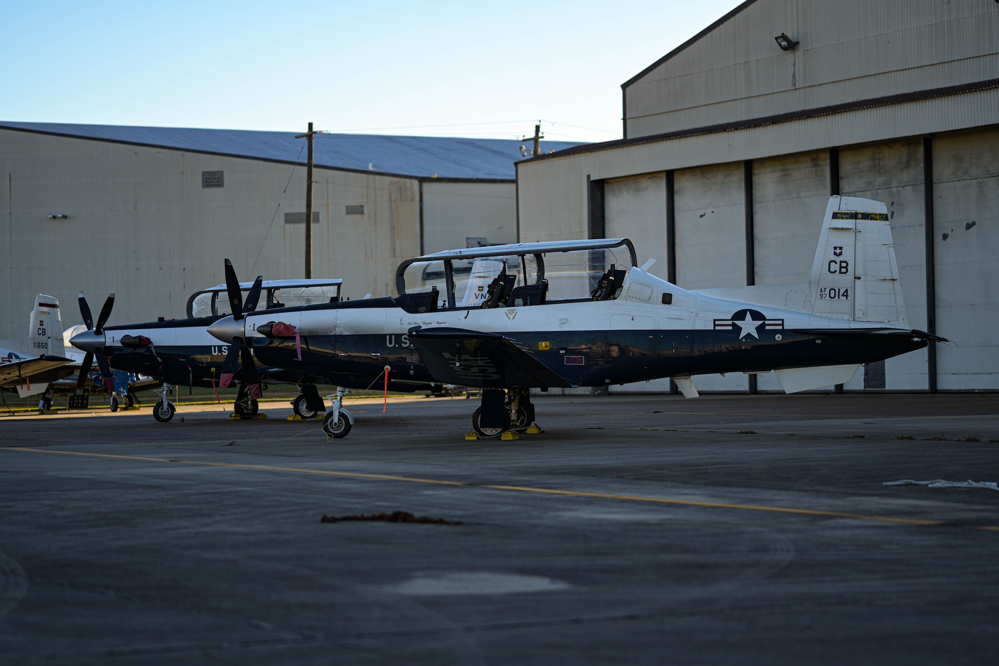 Three T-6A Texan II aircraft sit in the maintenance quadrant, September 30, 2022, on Columbus Air Force Base, Miss. Students fly the T-6 during the primary phase of training practicing aircraft control, including takeoff and landing techniques and aerobatics. (U.S. Air Force photo by Staff Sgt. Jake Jacobsen)