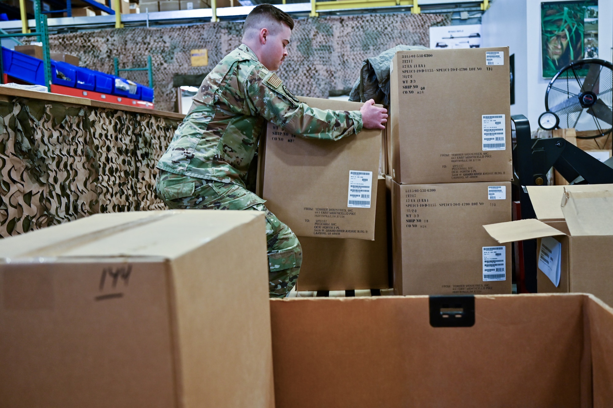 Staff Sgt. Jacob Wilson, 90th Logistics Readiness Squadron mobility NCOIC, moves boxes of parkas into a shipping container on F.E. Warren Air Force Base, Wyoming, Sept. 29, 2022. As part of a Department of Defense effort to provide foreign aid, the 90 LRS mobility flight packed and shipped 111 parkas to the front lines in Eastern Europe. (U.S. Air Force photo by Joseph Coslett)