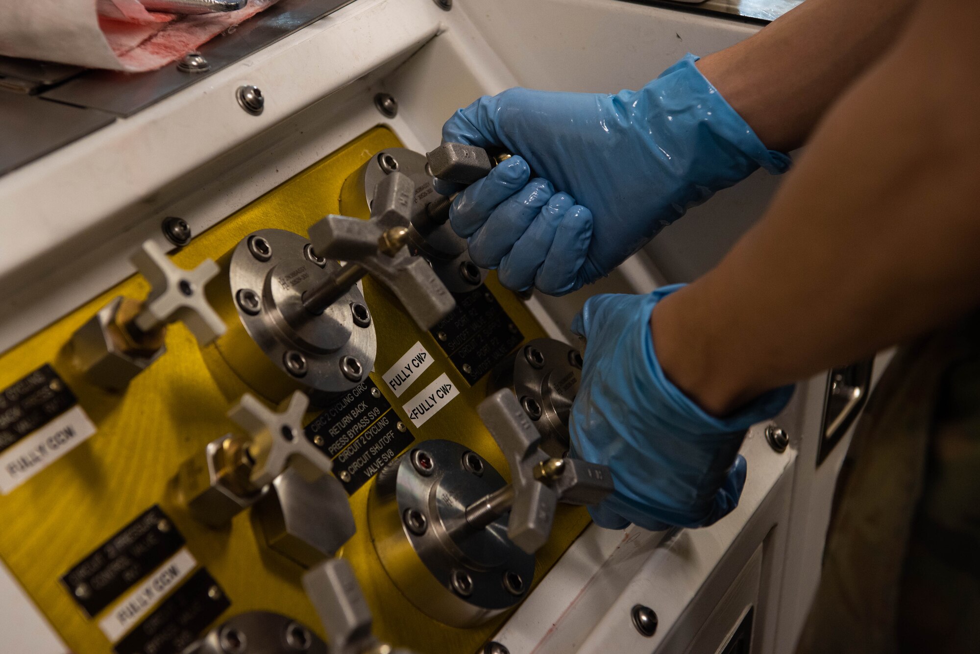 An Airman turns control knobs.