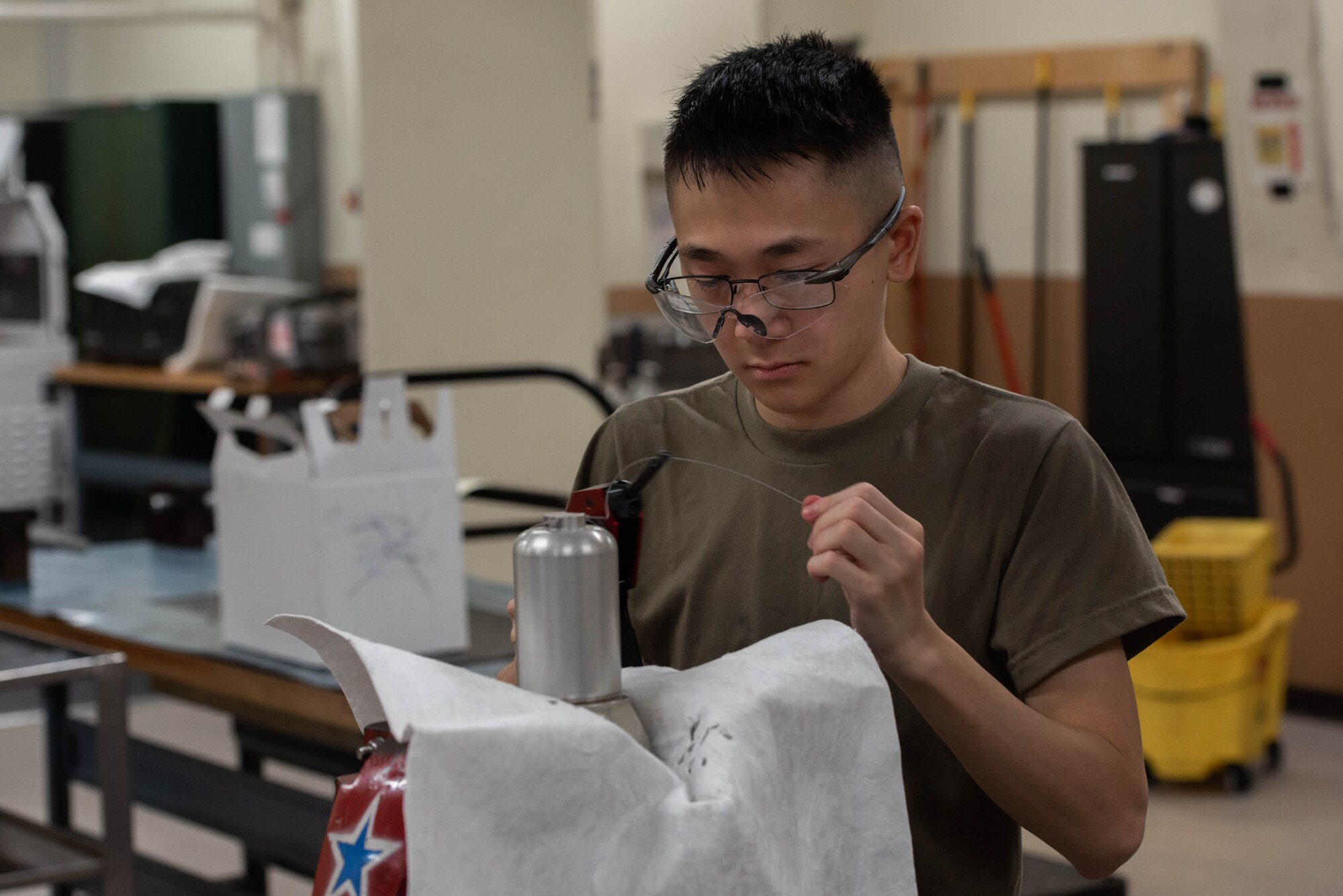 An Airman repairs a hydraulic component.