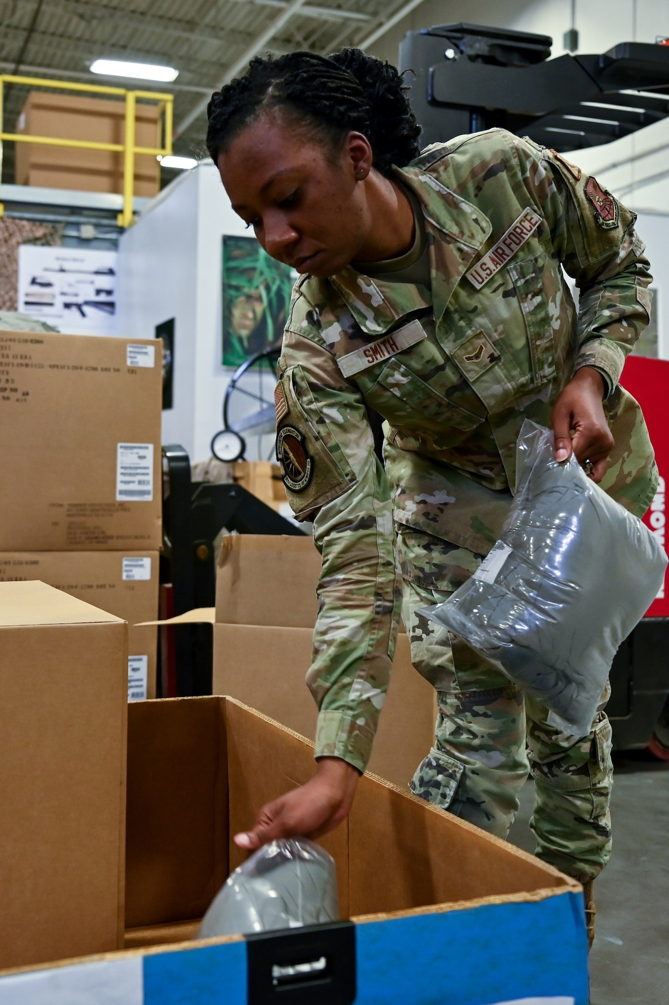 Airman 1st Class Destiny Smith, 90th Logistics Readiness Squadron mobility journeyman, transfers parkas into a shipping container on F.E. Warren Air Force Base, Wyoming, Sept. 29, 2022. As part of a Department of Defense effort to provide foreign aid, the 90 LRS mobility flight packed and shipped 111 parkas to the front lines in Eastern Europe. (U.S. Air Force photo by Joseph Coslett)