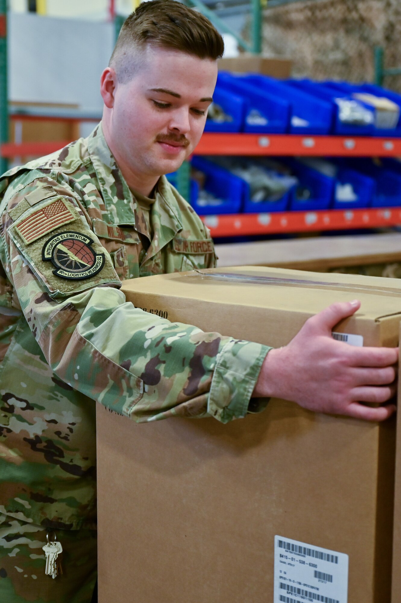 Staff Sgt. Jacob Wilson, 90th Logistics Readiness Squadron mobility NCOIC, moves boxes of parkas into a shipping container on F.E. Warren Air Force Base, Wyoming, Sept. 29, 2022. As part of a Department of Defense effort to provide foreign aid, the 90 LRS mobility flight packed and shipped 111 parkas to the front lines in Eastern Europe. (U.S. Air Force photo by Joseph Coslett)