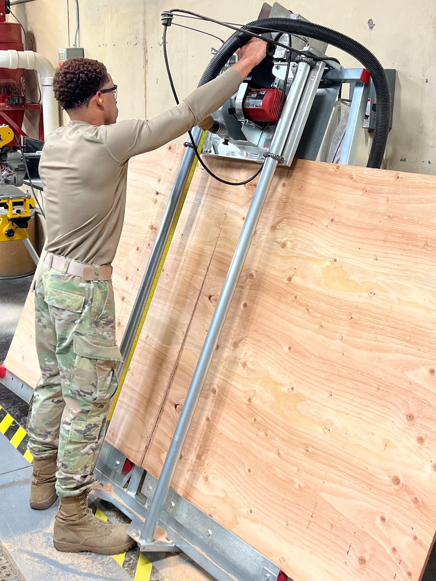 Staff Sgt. Kentrell Dragg, 90th Logistics Readiness Squadron NCOIC of packing and crating, uses a saw to create a custom lid for the packing crates on F.E. Warren Air Force Base, Wyoming, Sept. 29, 2022. As part of a Department of Defense effort to provide foreign aid, the 90 LRS mobility flight packed and shipped 111 parkas to the front lines in Eastern Europe. (U.S. Air Force photo by Robert DuPont)