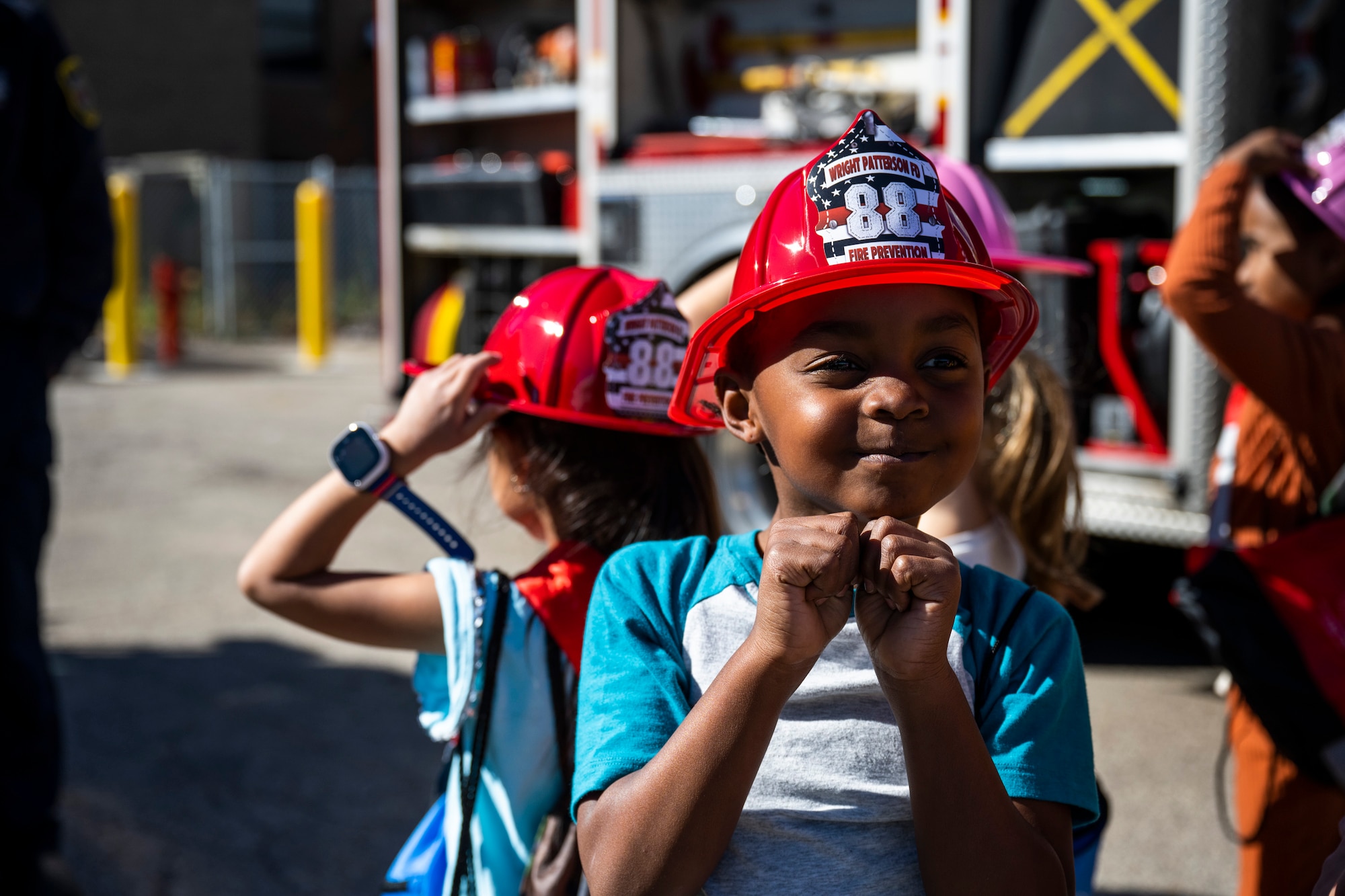 A child puts on a fire helmet.