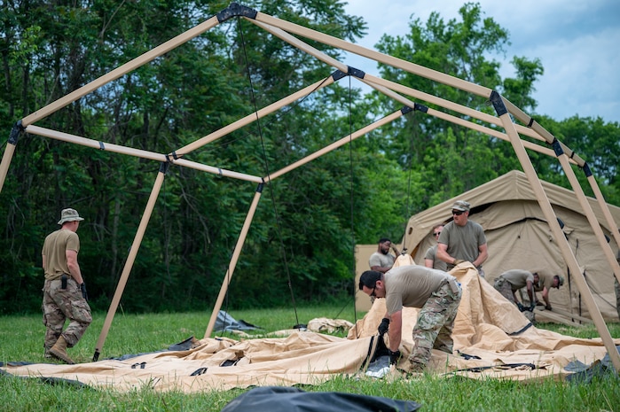 Members with the 27th Special Operations Wing Mission Sustainment Team Detachment 1 construct a tent during exercise Emerald Warrior 22.1 in Smyrna, Tennessee, May 5, 2022. The MST establishes forward-operating bases by providing initial site security, receiving cargo and personnel, and setting up shelter.