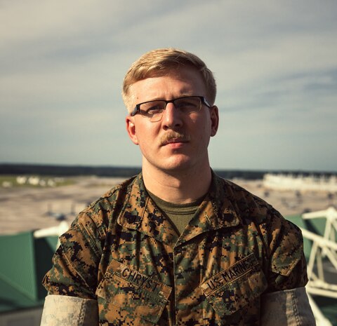 U.S. Marine Corps Sgt. Ian Chryst, Charlotte, North Carolina native, air traffic controller, Headquarters and Headquarters Squadron, Marine Corps Air Station (MCAS) New River, posing from the control tower on MCAS New River in Jacksonville, North Carolina, Sept. 14, 2022. Chryst was selected for this month's MCAS New River Go-Getter award due to his professionalism and for filling a staff noncommissioned officers role as a sergeant. (U.S. Marine Corps photo by Lance Cpl. Zachary Zephir)