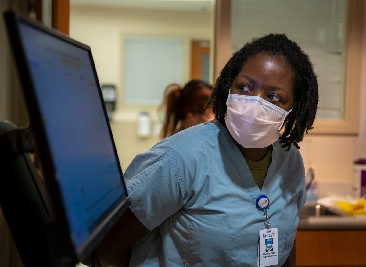 Tech. Sgt. Erika Williams, 932nd Medical Squadron medical technician, works with a civilian patient at Mercy Hospital.