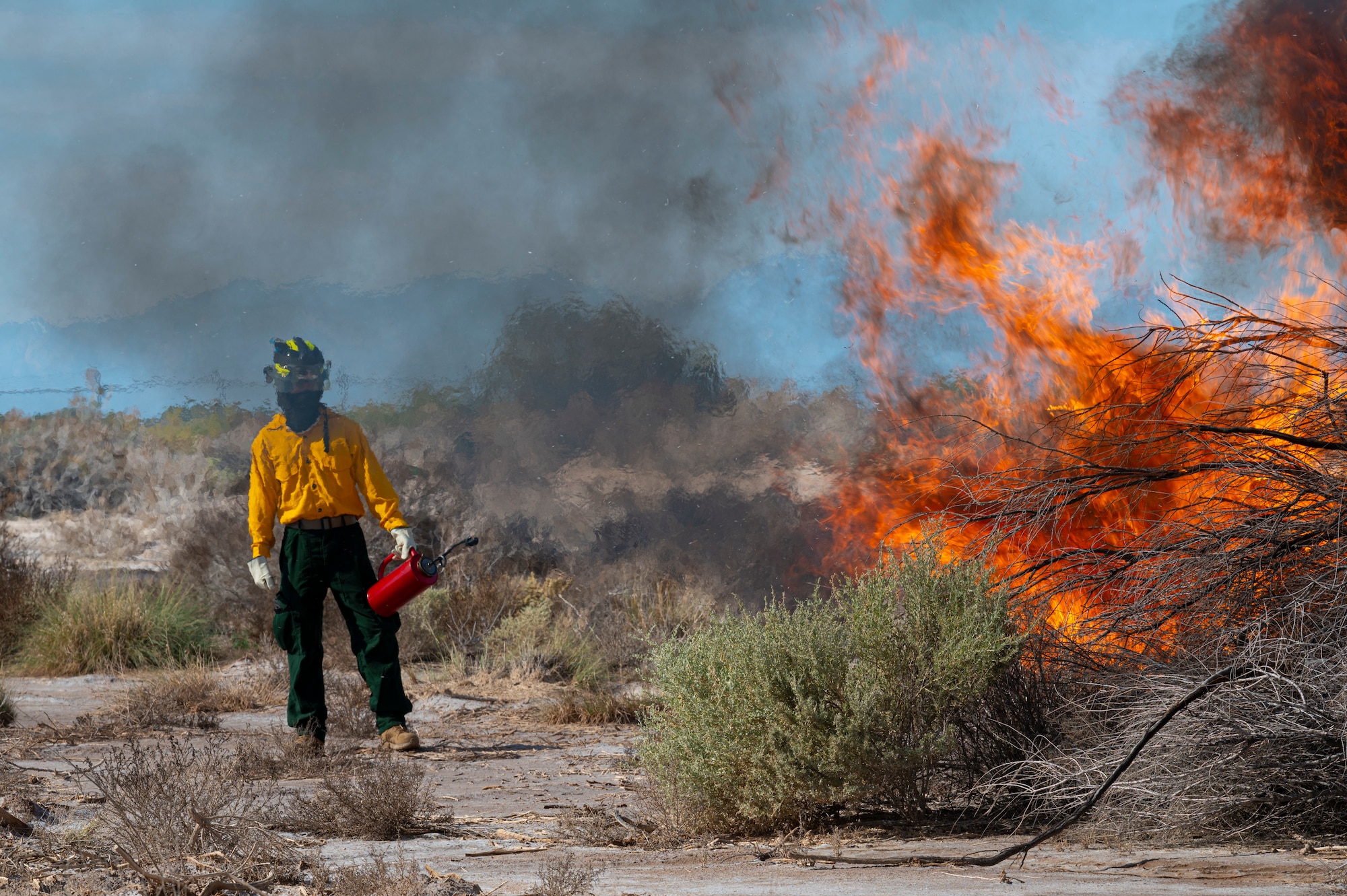 U.S. Air Force Airman 1st Class Joshua Paculan, 49th Civil Engineer Squadron firefighter, observes a brush fire during a prescribed burn at Holloman Air Force Base, New Mexico, Oct. 3, 2022. Prescribed burns ensure that the environment and wildlife on base remain healthy. (U.S. Air Force photo by Airman 1st Class Isaiah Pedrazzini)