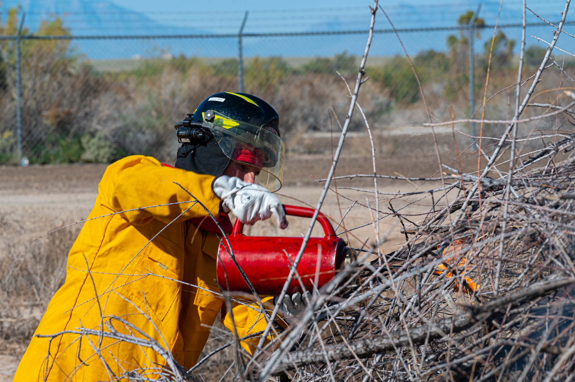 U.S. Air Force Senior Airman Dawson Ogletree, 49th Civil Engineer Squadron firefighter, ignites a pile of brush during a prescribed burn at Holloman Air Force Base, New Mexico, Oct. 3, 2022. Prescribed burns help to prevent occurrence of wildfires on base. (U.S. Air Force photo by Airman 1st Class Isaiah Pedrazzini)
