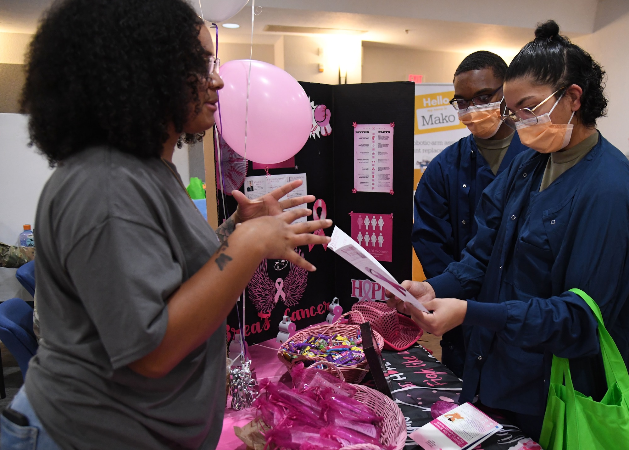 U.S. Air Force Tech. Sgt. Elaina Pea, 81st Diagnostic and Therapeutics Squadron radiology section chief, provides mammography literature to Airmen 1st Class Gabriel Dudley and Verlene Johnson, 81st Dental Squadron dental technicians, during the 11th Annual 81st Medical Group Health Expo inside the Keesler Medical Center auditorium at Keesler Air Force Base, Mississippi, October 7, 2022. The 81st MDG hosted the walk-in event, which included information booths and scheduling appointments for multiple types of cancer and chronic diseases in honor of Breast Cancer Awareness Month. (U.S. Air Force photo by Kemberly Groue)