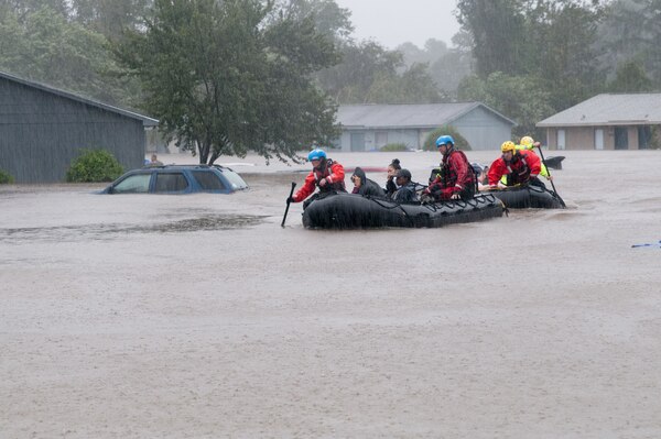People in boats in floodwaters.