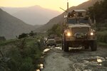 Trucks drive along a treacherous mountain road.