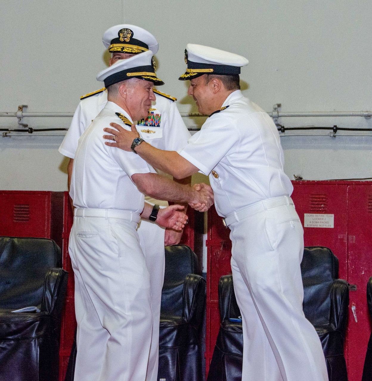 Capt. Fred Goldhammer, right, commanding officer of the U.S. Navy’s only forward-deployed aircraft carrier, USS Ronald Reagan (CVN 76), and Capt. Daryle Cardone, left, prospective commanding officer of Ronald Reagan, shake hands after reading their official orders during a change of command ceremony in the Sea of Japan, Oct 7. Ronald Reagan, the flagship of Carrier Strike Group 5, provides a combat-ready force that protects and defends the United States, and supports alliances, partnerships and collective maritime interests in the Indo-Pacific region. (U.S. Navy photo by Mass Communication Specialist Seaman Natasha ChevalierLosada)