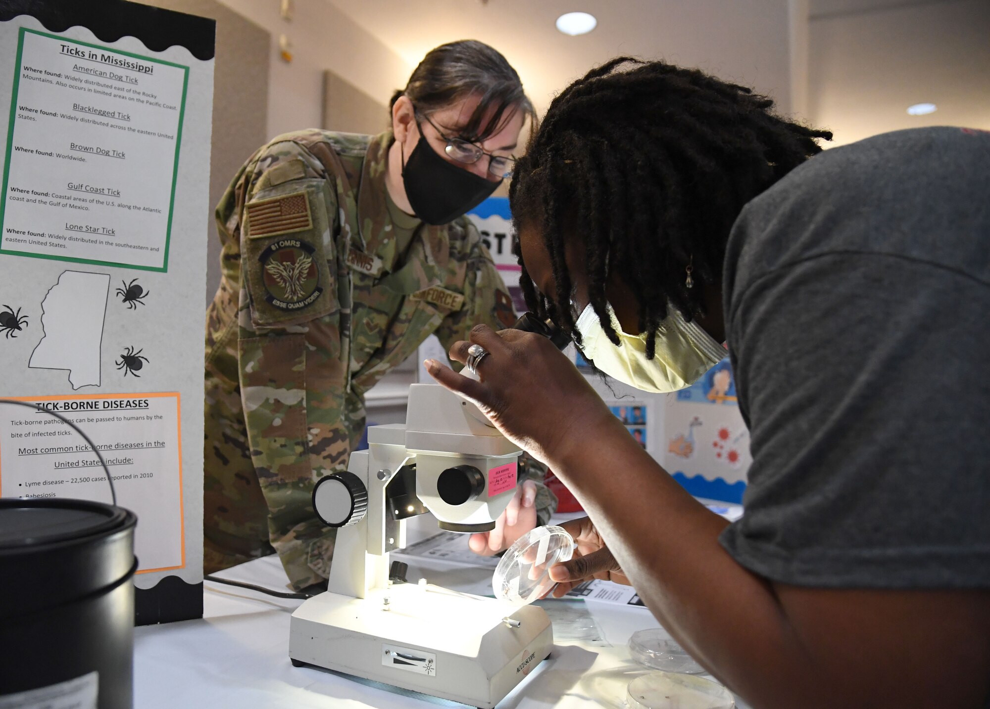 U.S. Air Force Senior Airman Jennifer McGinnis, 81st Operational Medical Readiness Squadron public health technician, provides insect examples to retired Master Sgt. Tarissa Brown, during the 11th Annual 81st Medical Group Health Expo inside the Keesler Medical Center auditorium at Keesler Air Force Base, Mississippi, October 7, 2022. The 81st MDG hosted the walk-in event, which included information booths and scheduling appointments for multiple types of cancer and chronic diseases in honor of Breast Cancer Awareness Month. (U.S. Air Force photo by Kemberly Groue)