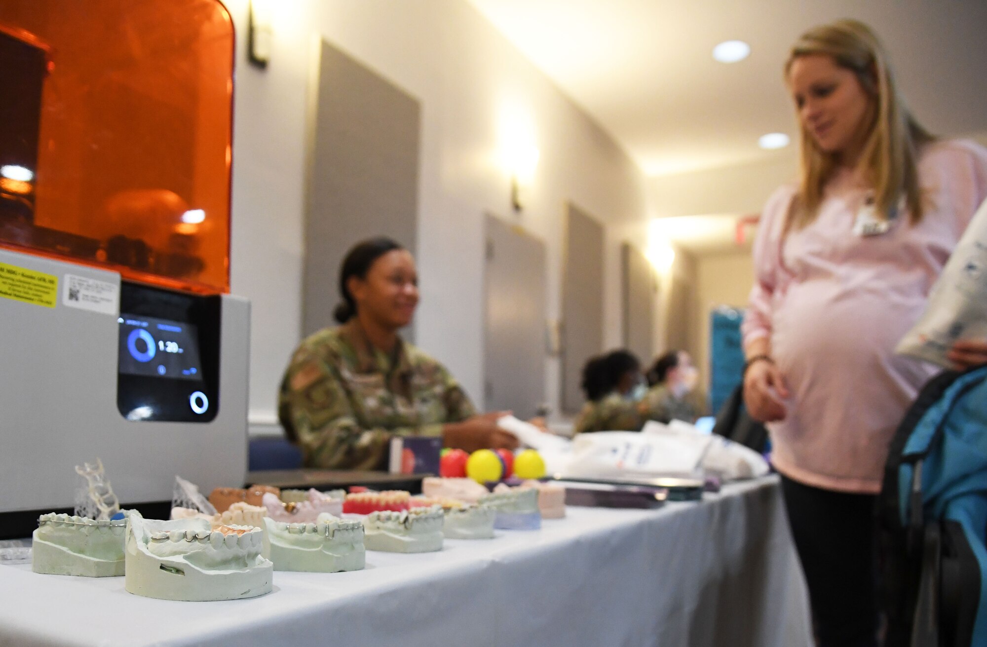 U.S. Air Force Staff Sgt. Lekevia Hayes, 81st Dental Squadron residency NCO in charge, provides dental care literature to Capt. Katie Armstrong, 81st Healthcare Operations Squadron ER clinical nurse, during the 11th Annual 81st Medical Group Health Expo inside the Keesler Medical Center auditorium at Keesler Air Force Base, Mississippi, October 7, 2022. The 81st MDG hosted the walk-in event, which included information booths and scheduling appointments for multiple types of cancer and chronic diseases in honor of Breast Cancer Awareness Month. (U.S. Air Force photo by Kemberly Groue)