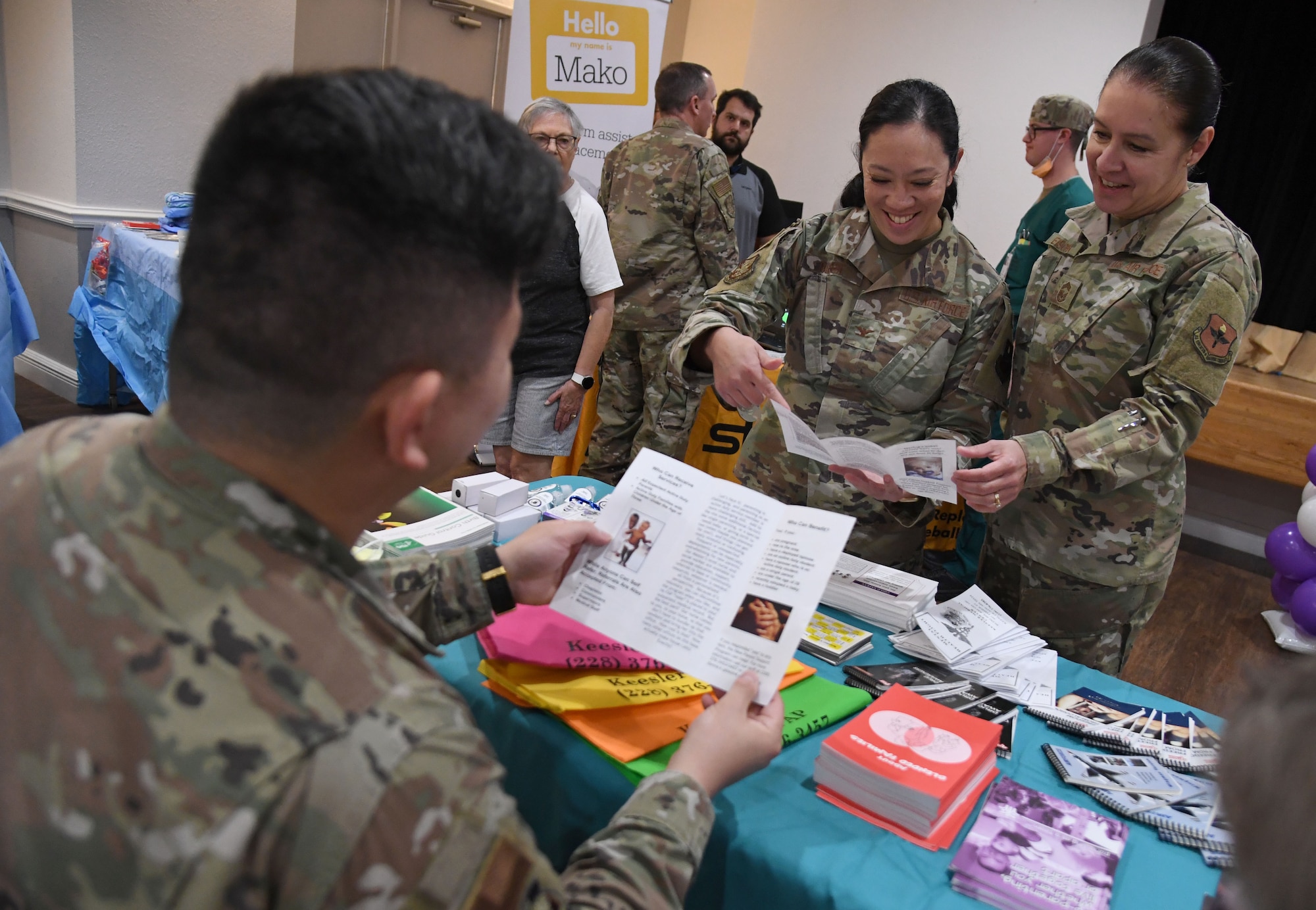 U.S. Air Force Tech. Sgt. Alex Chung, 81st Operational Medical Readiness Squadron mental health NCO in charge, provides mental health and family advocacy literature to Col. Lynne Bussie, 81st Medical Group deputy commander, and Chief Master Sgt. Paula Eischen, 81st MDG senior enlisted leader, during the 11th Annual 81st Medical Group Health Expo inside the Keesler Medical Center auditorium at Keesler Air Force Base, Mississippi, October 7, 2022. The 81st MDG hosted the walk-in event, which included information booths and scheduling appointments for multiple types of cancer and chronic diseases in honor of Breast Cancer Awareness Month. (U.S. Air Force photo by Kemberly Groue)