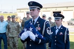 167th Airlift Wing Base Honor Guard members, Master Sgt. Geoffrey Blankenship and Airman 1st Class Elizabeth Casteel, proceed with an American flag to the front of the 167th Operations Group building to perform a flag folding for the Decoy 81 memorial ceremony at the wing, Oct. 7, 2022.