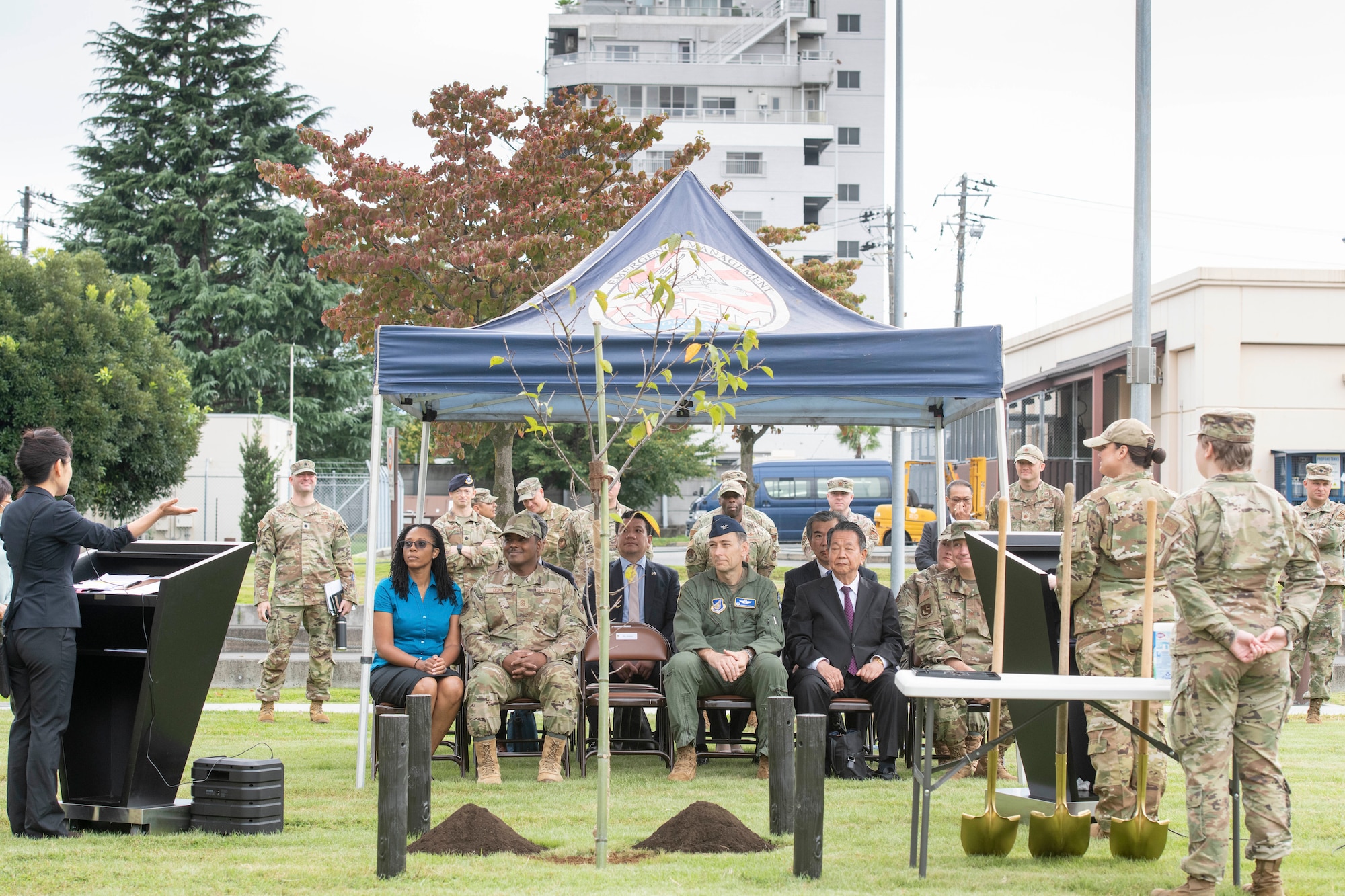 Attendees of a tree planting ceremony listen to the event’s emcees at Yokota Air Base, Japan, Oct. 5, 2022.