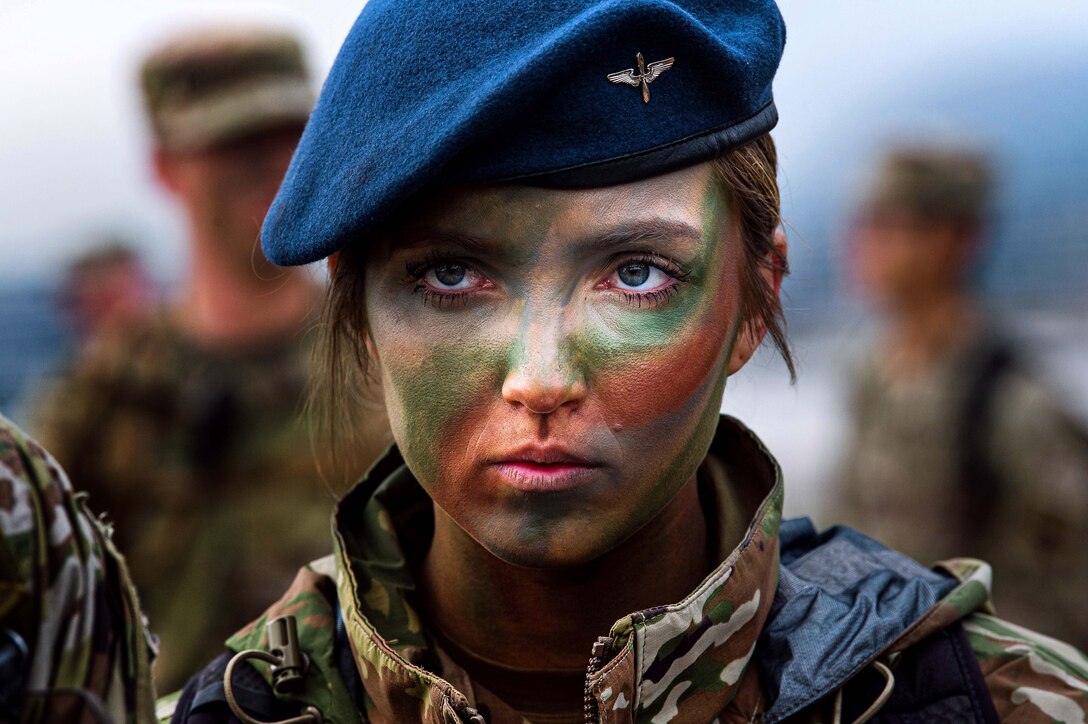 An Air Force cadet with camouflage on her face looks forward.