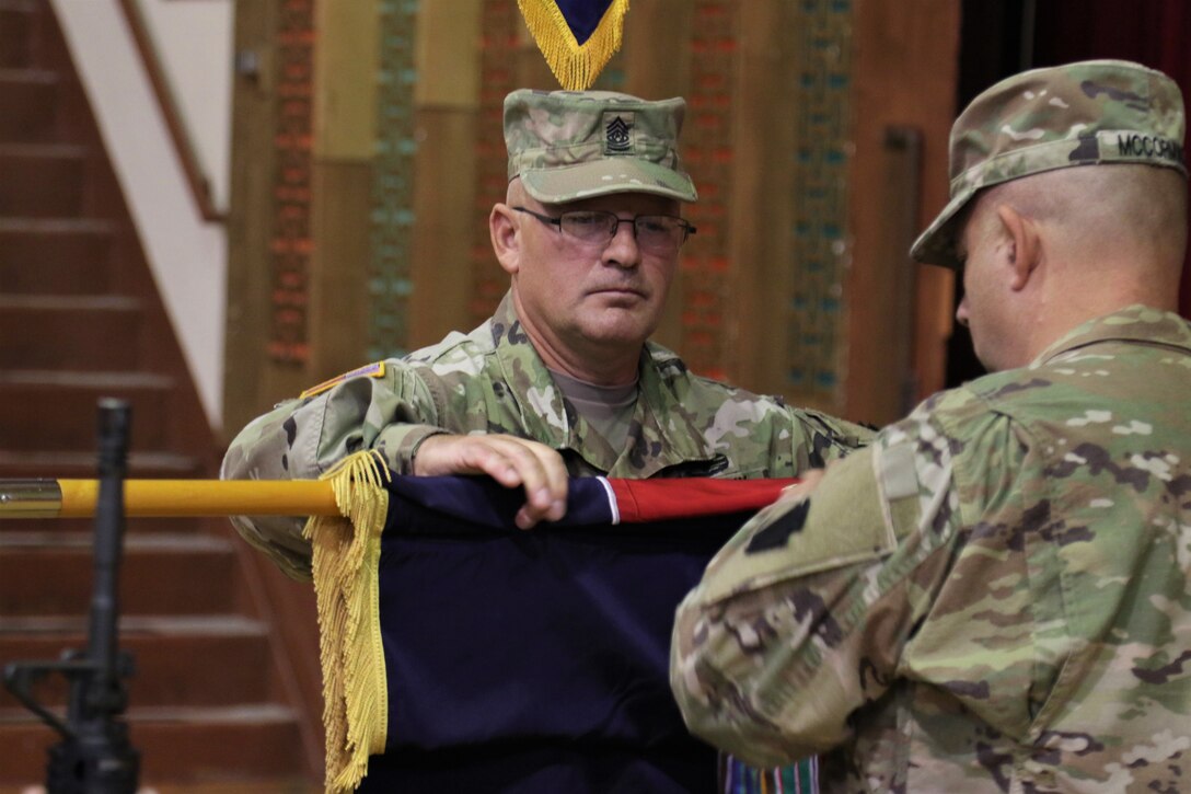 U.S. Army Command Sgt. Maj. Randall Pritts, senior enlisted leader of the 28th Infantry Division, cases the division colors during a deployment ceremony at Zembo Shrine Auditorium, signaling that the division is leaving home and is ready for its overseas mission. The colors will be uncased when they formally take authority of their mission in the Middle East.