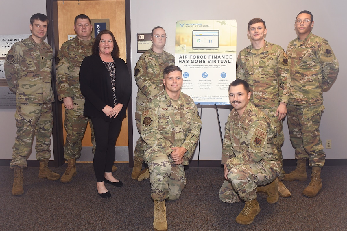Military and civilian men and women pose for group ohoto