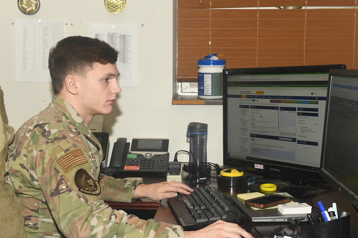 Man sits at desk while working on computer