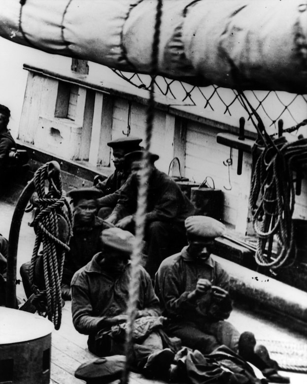 Black crew members sewing and relaxing on the forecastle, starboard side, of USS Miami circa 1864-65. This image is a detail from the right side of Photo # NH 60873. U.S. Naval History and Heritage Command Photograph. (NH 55510)