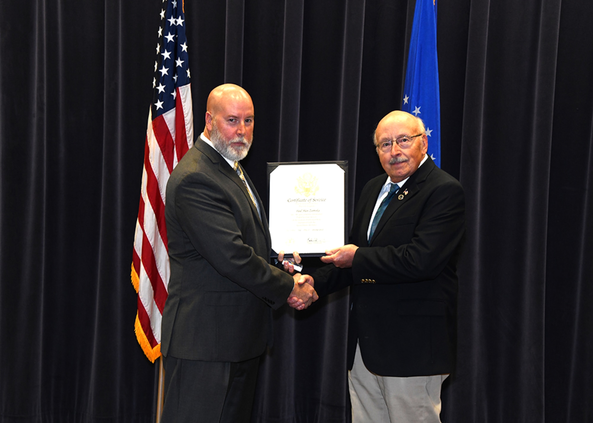 Marty Fagan presents Paul Alan Zamiska with a certificate of service during a retirement ceremony in the 557th Weather Wing’s Chief Master Sgt. Peter Morris auditorium on Offutt Air Force Base, Nebraska Sept. 30.