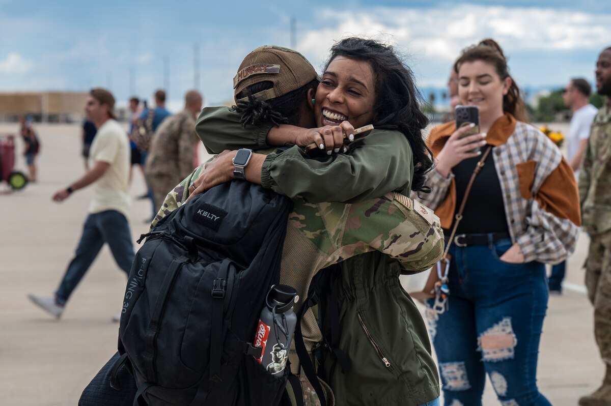 A photo of an Airman hugging a friend