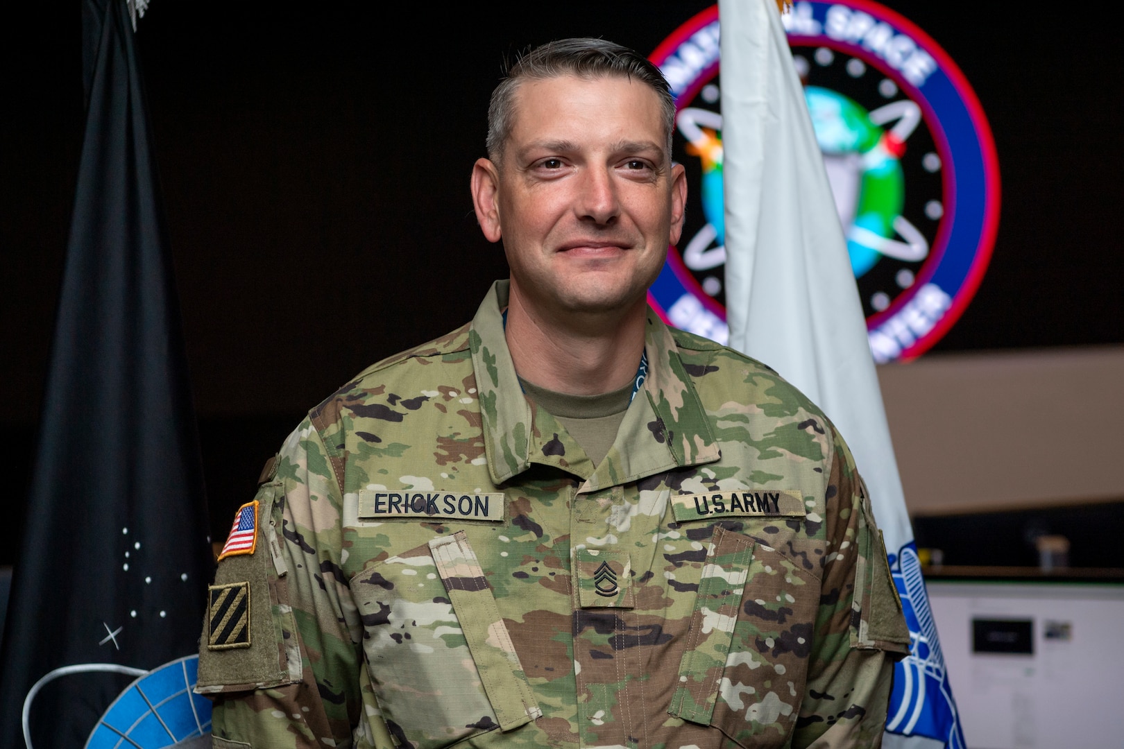 Man in military uniform smiles for a photo