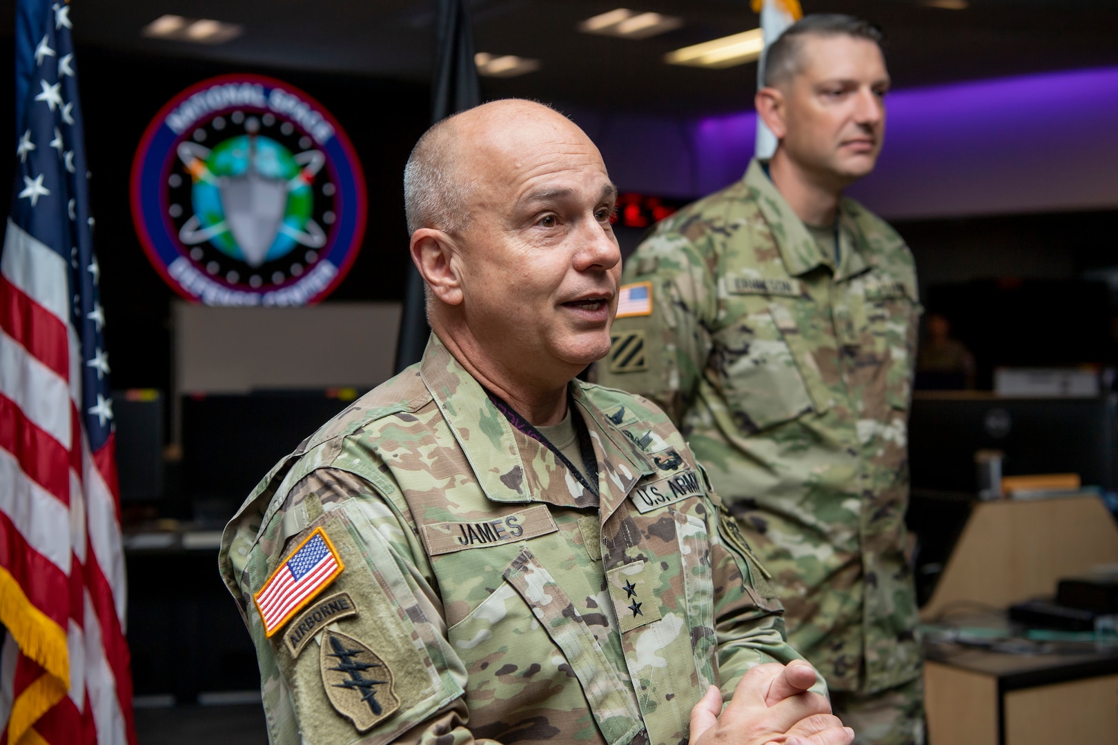 Man in military uniform gives remarks during an interservice transfer ceremony