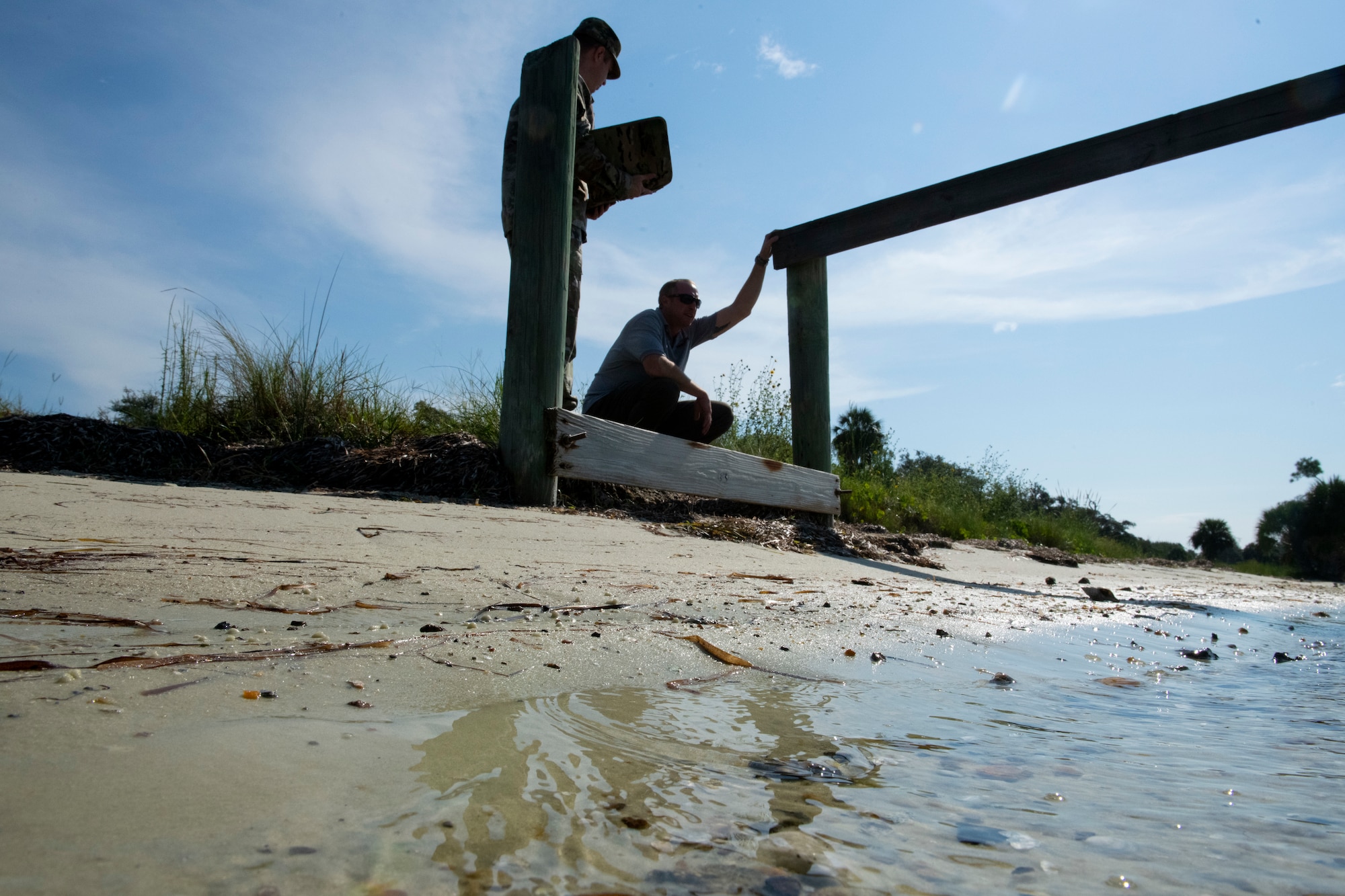 From left, U.S. Air Force Staff Sgt. Adam Mitcheltree, 325th Contracting Squadron contract specialist, and David Hagner, a contractor working with Tyndall Air Force Base, discuss restoration plans at Tyndall AFB, Florida, Sept. 13, 2022.
