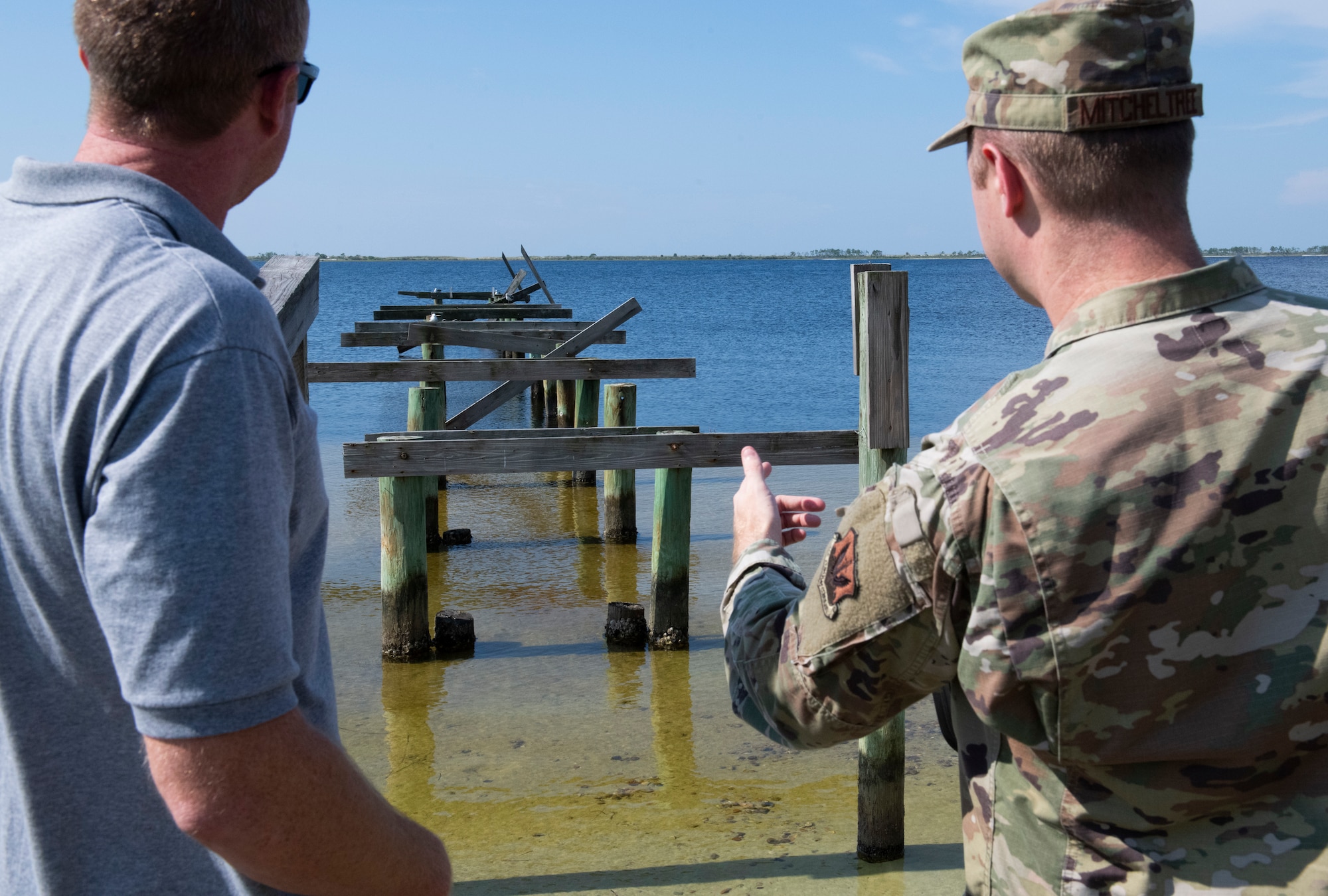 From left, David Hagner, a contractor working with Tyndall Air Force Base, and U.S. Air Force Staff Sgt. Adam Mitcheltree, 325th Contracting Squadron contract specialist, discuss restoration plans for a pier at Tyndall AFB, Florida, Sept. 13, 2022.