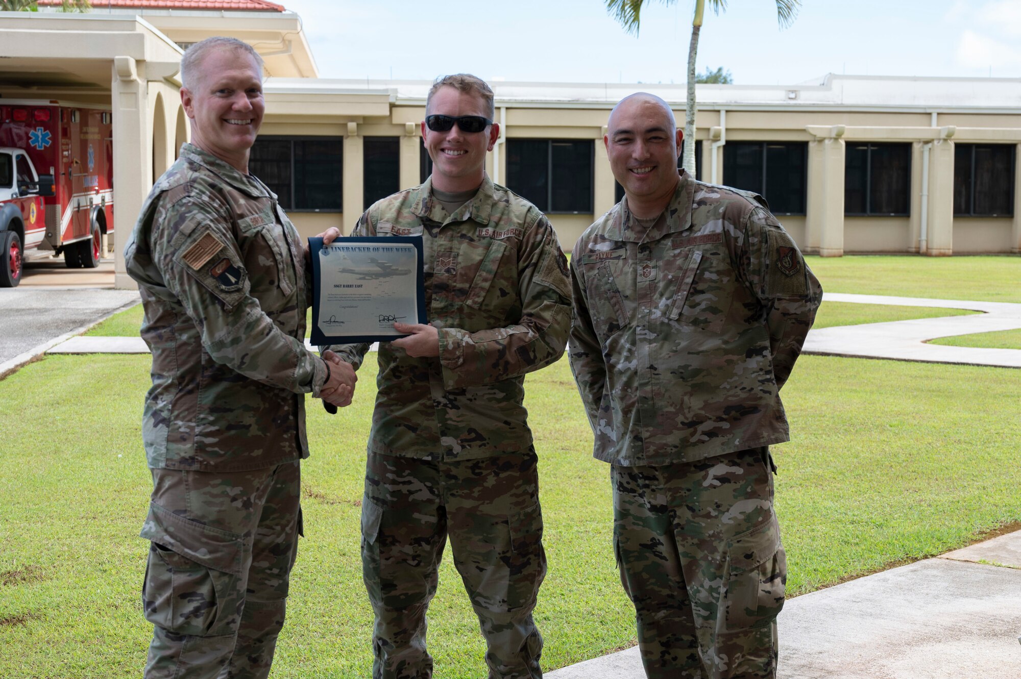 U.S. Air Force Staff Sgt. Barry East, the noncommissioned officer in charge of health information systems assigned to the 36th Healthcare Operations Squadron, receives the Linebacker of the Week Award from U.S. Air Force Brig. Gen. Paul Birch, commander of the 36th Wing, and U.S. Air Force Chief Master Sgt. John Payne, the command chief of the 36th Wing, at Andersen Air Force Base, Guam, Oct. 5, 2022. The Team Andersen Linebacker of the Week recognizes outstanding enlisted, officer, civilian and total force personnel who have had an impact on achieving Team Andersen’s mission, vision and priorities. (U.S. Air Force photo by Airman 1st Class Emily Saxton)