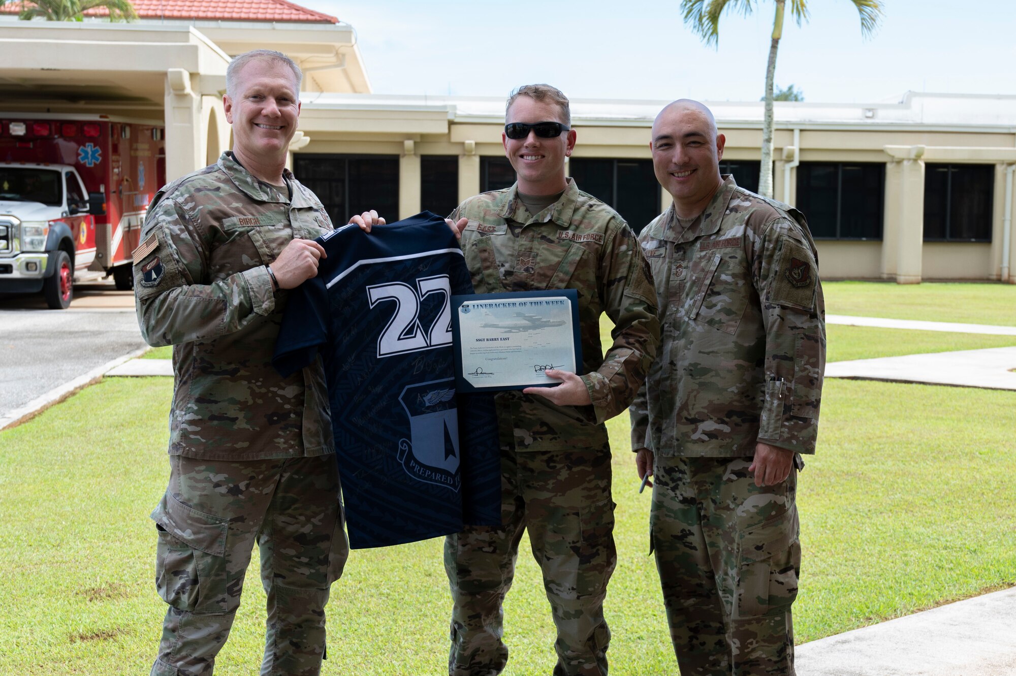 U.S. Air Force Staff Sgt. Barry East, the noncommissioned officer in charge of health information systems assigned to the 36th Healthcare Operations Squadron, receives the Linebacker of the Week Award from U.S. Air Force Brig. Gen. Paul Birch, commander of the 36th Wing, and U.S. Air Force Chief Master Sgt. John Payne, the command chief of the 36th Wing, at Andersen Air Force Base, Guam, Oct. 5, 2022. The Team Andersen Linebacker of the Week recognizes outstanding enlisted, officer, civilian and total force personnel who have had an impact on achieving Team Andersen’s mission, vision and priorities. (U.S. Air Force photo by Airman 1st Class Emily Saxton)