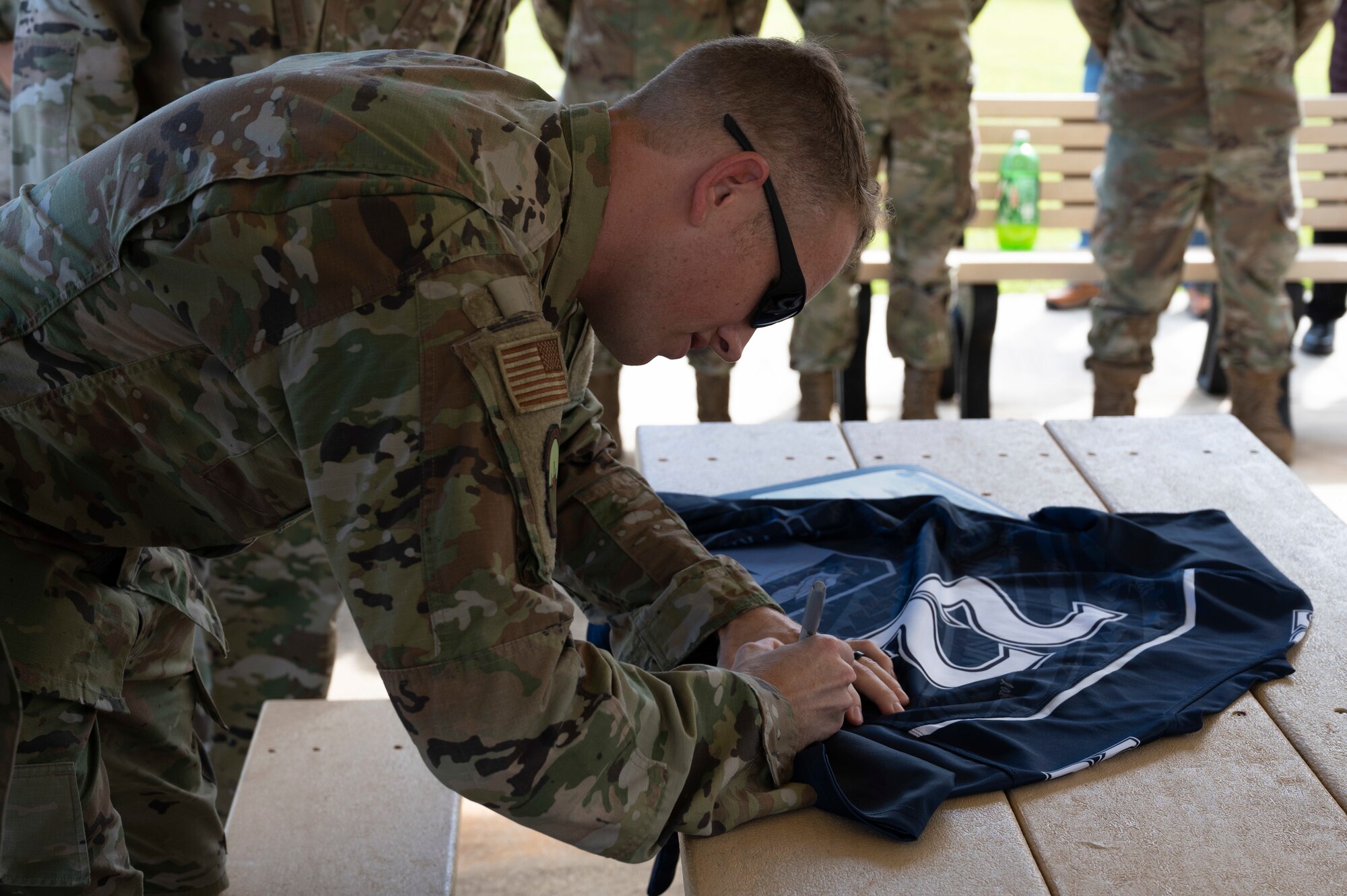 U.S. Air Force Staff Sgt. Barry East, the noncommissioned officer in charge of health information systems assigned to the 36th Healthcare Operations Squadron, signs the official Linebacker of the Week jersey at Andersen Air Force Base, Guam, Oct. 5, 2022. The Team Andersen Linebacker of the Week recognizes outstanding enlisted, officer, civilian and total force personnel who have had an impact on achieving Team Andersen’s mission, vision and priorities. (U.S. Air Force photo by Airman 1st Class Emily Saxton)