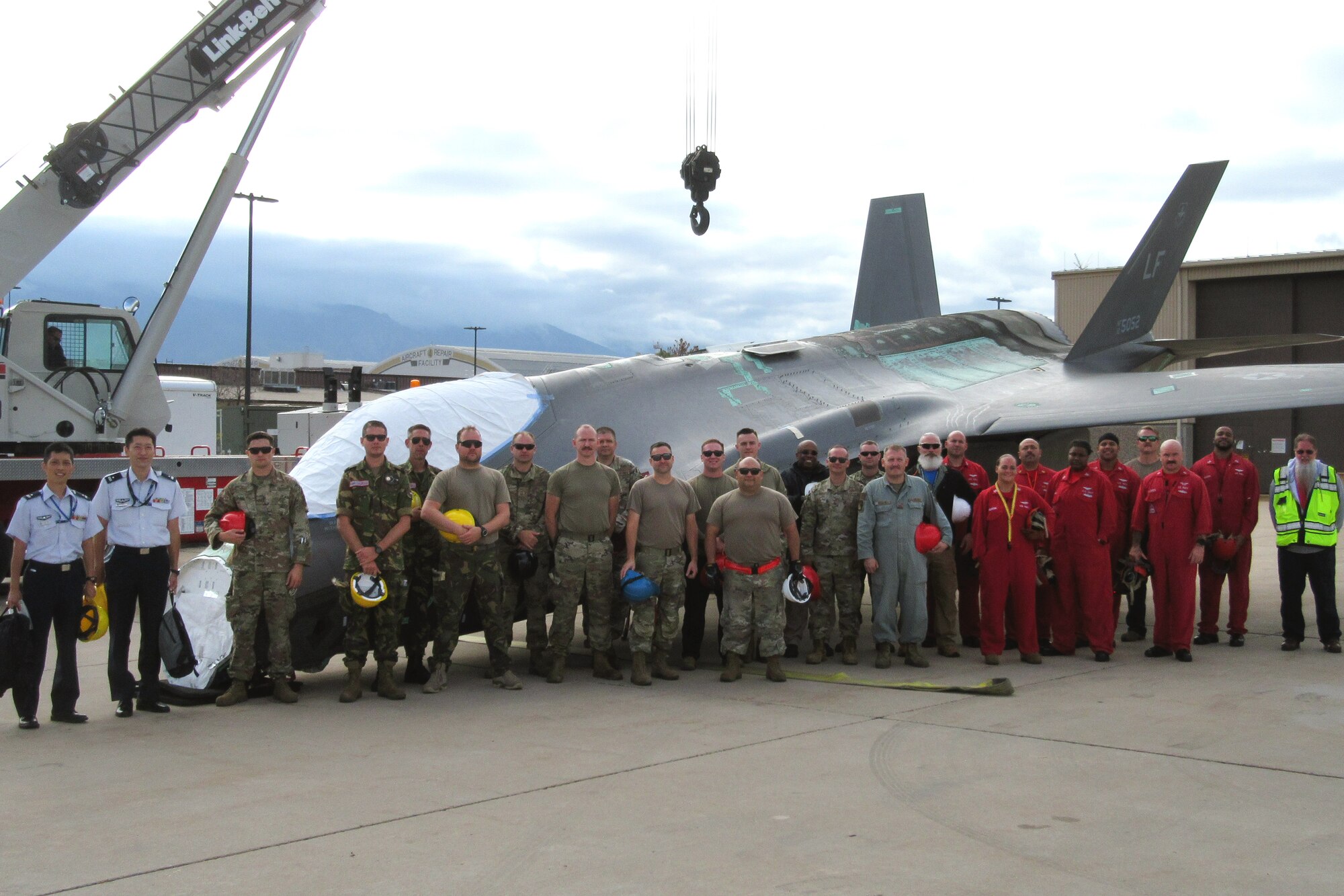 Course participants gather for a group photo in front of a reassembled F-35.