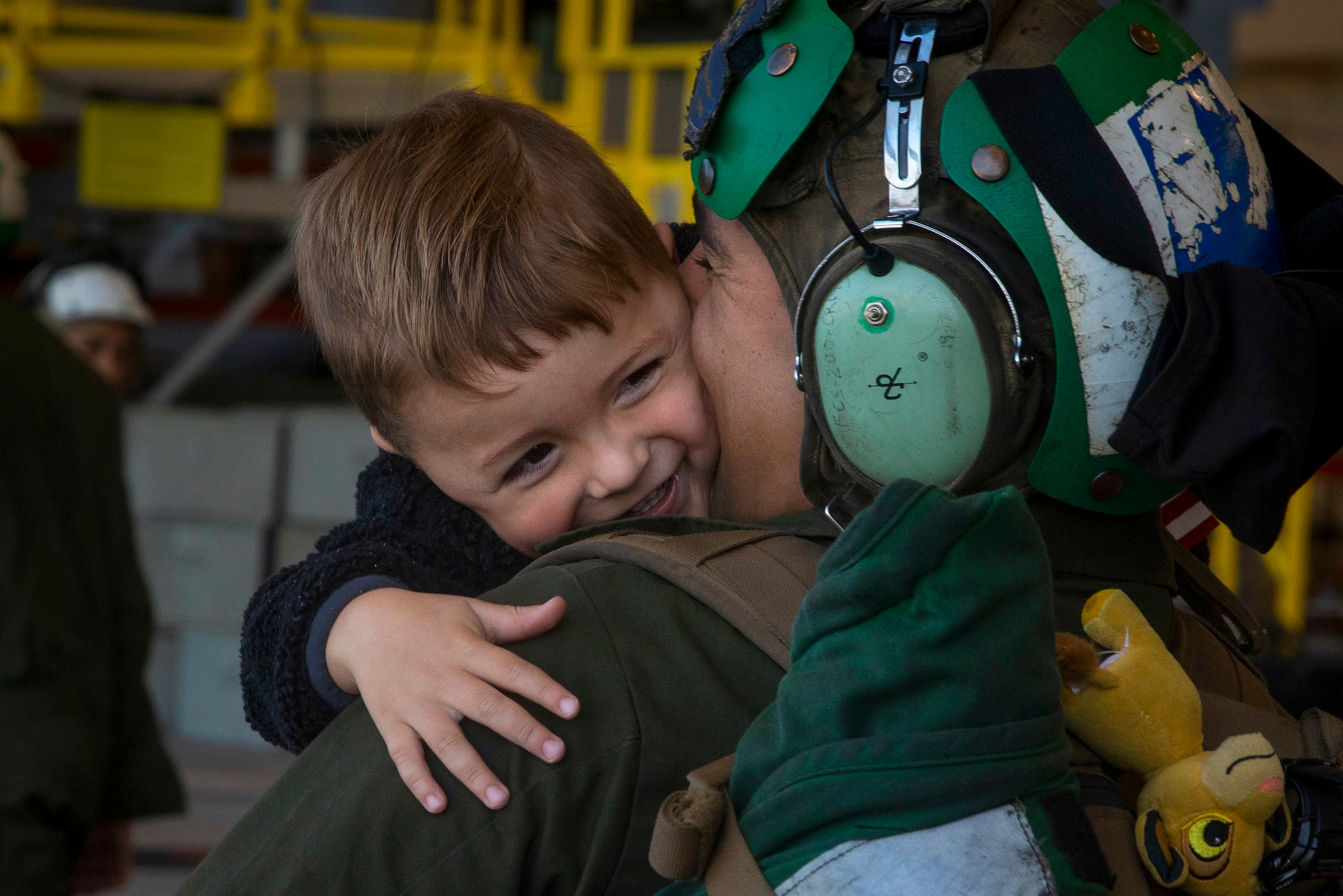 A Marine holds a smiling boy.