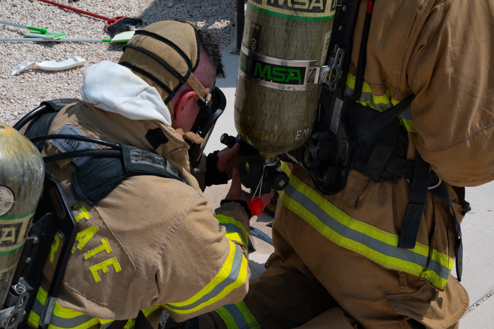 U.S. Air Force Tech Sgt. Kyle Trengo, a firefighter assigned to the 1st Expeditionary Civil Engineer Group, Expeditionary Prime Beef Squadron, Quick Strike Team Fire, conducts a buddy check to ensure partners personal protective equipment is on correctly during an exercise Aug. 30, 2022 at Al Udeid Air Base, Qatar. The firefighters entered a simulated hazardous environment to search for potential victims during an exercise. (U.S. Air Force photo by Staff Sgt. Dana Tourtellotte)