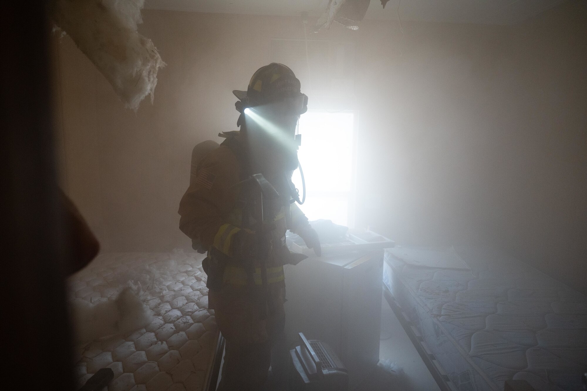 U.S. Air Force Senior Airman William Webber, a firefighter and acting crew chief assigned to the 379th Expeditionary Civil Engineer Squadron searches a room during an exercise Aug. 30, 2022 at Al Udeid Air Base, Qatar. The firefighters performed a systematic search pattern looking for victims and potential fire spread while also performing a venting operation to remove smoke and harmful gases from the building. (U.S. Air Force photo by Staff Sgt. Dana Tourtellotte)