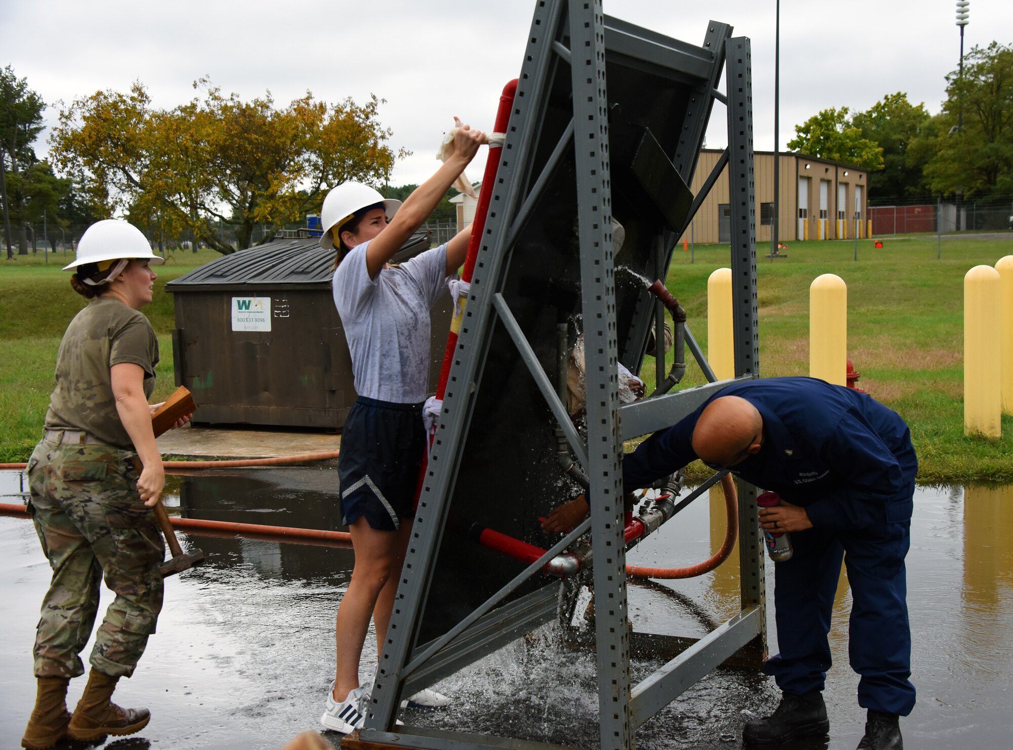 A class instructor increases water pressure while students are repairing an object.