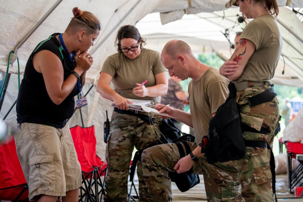 Air Force Capt. Daxton Duncan, a provider with the 181st Medical Group and Capt. Alyssa Doak, a nurse with the 181st Medical Group, Indiana Air National Guard assess a patient and perform simulated emergency procedures in a medical tent during the 19th Chemical, Biological, Radiological, Nuclear, and high-yield Explosives Enhanced Response Force Package pre-external evaluation sustainment year collective training event at Camp Atterbury Joint Maneuver Training Center, Ind., Aug. 10, 2022.