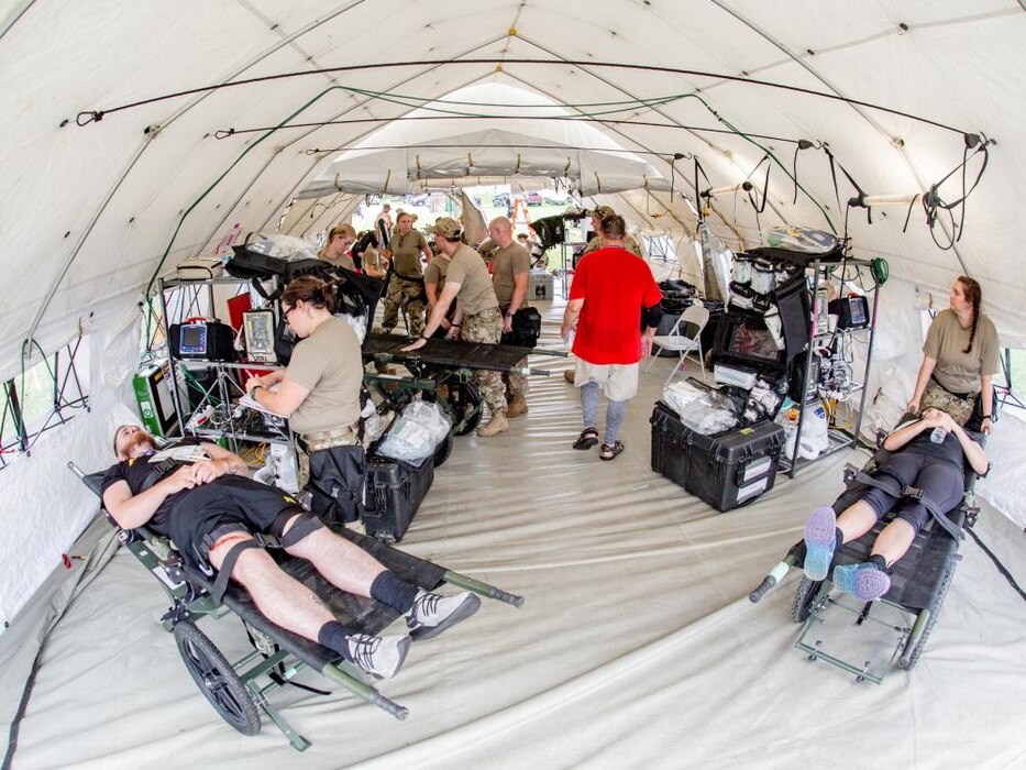 Airmen assigned to the 181st Medical Group, Indiana Air National Guard assess patients and perform simulated emergency procedures in a medical tent during the 19th Chemical, Biological, Radiological, Nuclear, and high-yield Explosives Enhanced Response Force Package pre-external evaluation sustainment year collective training event at Camp Atterbury Joint Maneuver Training Center, Ind., Aug. 11, 2022.