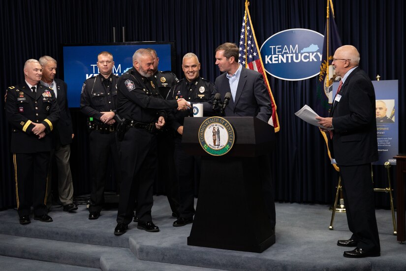 Kentucky Governor Andy Beshear (at podium) and Philip Miller, Kentucky chairman of the Employer Support of the Guard and Reserve(ESGR) presents the Secretary of Defense Freedom Award to Flemingsburg Police Chief Brian Bowling, at the Kentucky State Capitol in Frankfort, Ky. on Sept. 29, 2022. The Freedom Award is given to civilian employers of the Guard and Reserves by the ESGR for exceptional commitment to servicemembers' military careers. (U.S. Army photo by Andy Dickson)