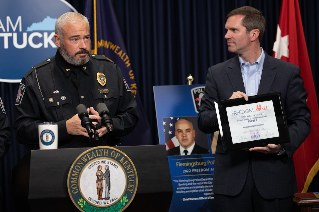 Felmingsburg Police Chief Brian Bowling (left) is presented the Secretary of Defense Freedom Award by Kentucky Governor Andy Beshear (right) at the Kentucky State Capitol in Frankfort, Ky. on Sept. 29, 2022. The Freedom Award is given to civilian employers of the Guard and Reserves by the ESGR for exceptional commitment to servicemembers' military careers. (U.S. Army photo by Andy Dickson)