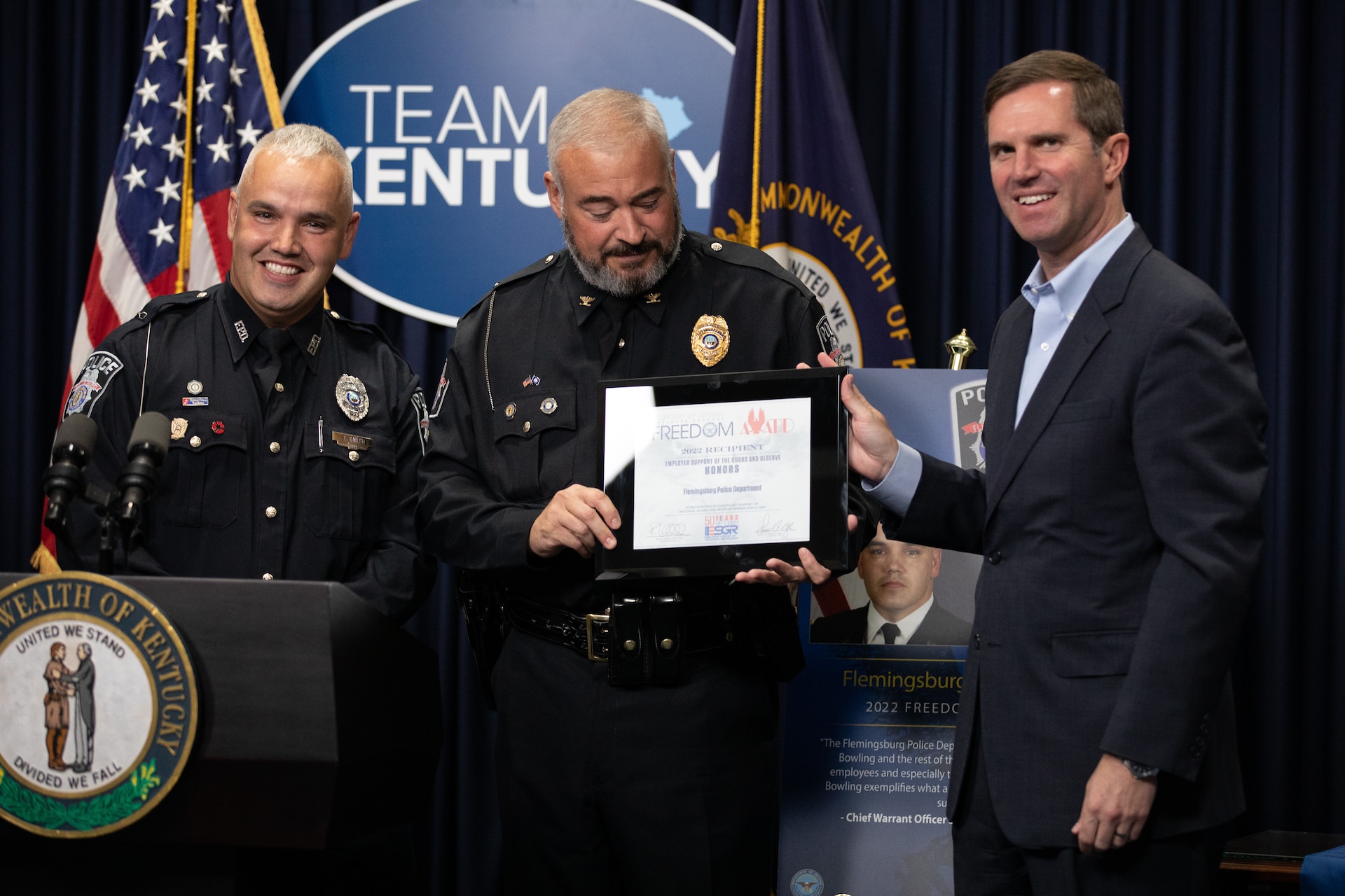 Chief Warrant Officer Timothy Smith (left) and Felmingsburg Police Chief Brian Bowling (center) are presented the Secretary of Defense Freedom Award by Kentucky Governor Andy Beshear (right) at the Kentucky State Capitol in Frankfort, Ky. on Sept. 29, 2022. The Freedom Award is given to civilian employers of the Guard and Reserves by the ESGR for exceptional commitment to servicemembers' military careers. (U.S. Army photo by Andy Dickson)