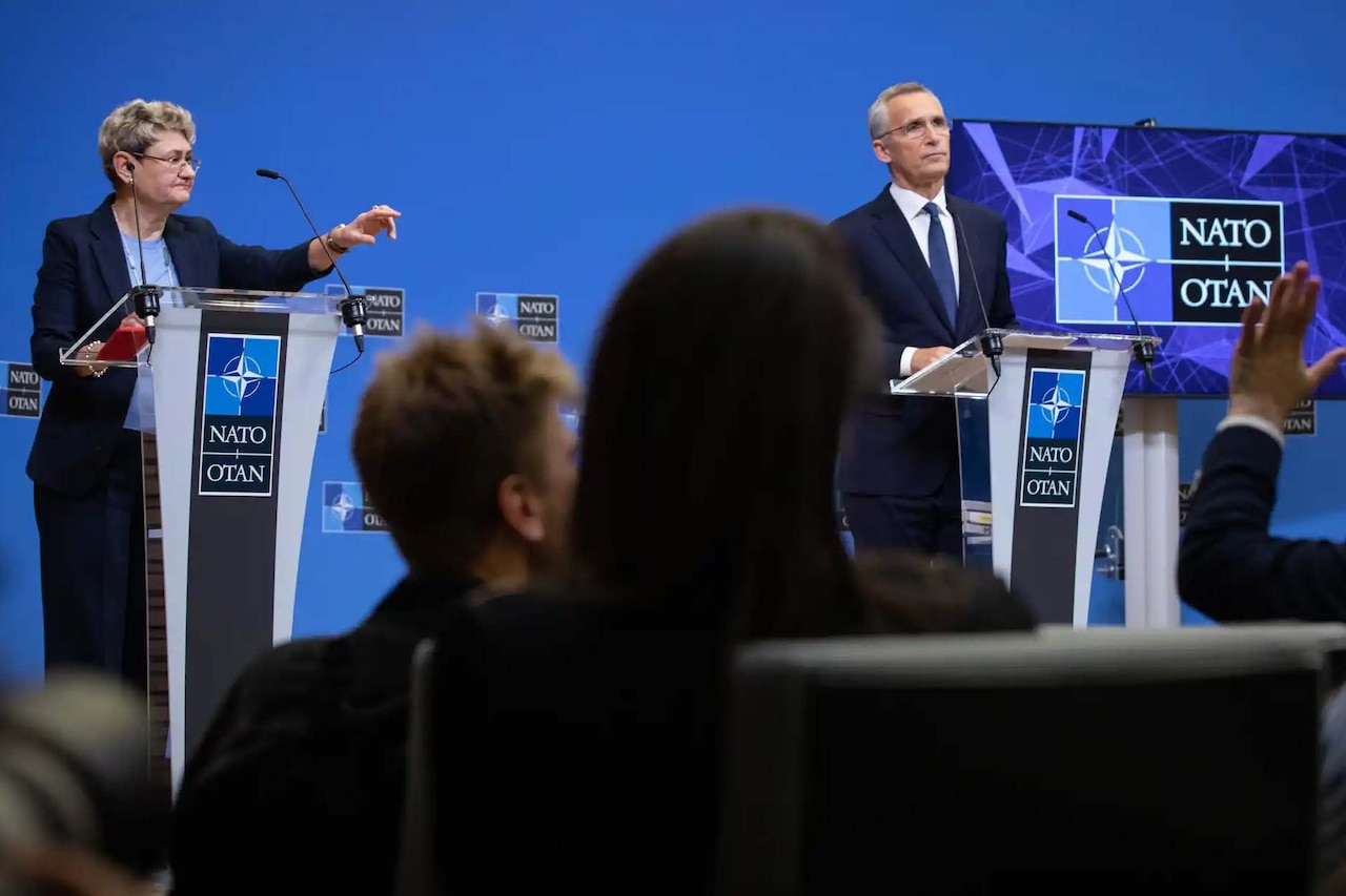 A man and a woman stand at lecterns.