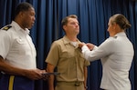 U.S. Navy Cmdr. Michael Keppen, former Eastern Sector deputy commander, receives a Joint Service Commendation Medal from U.S. Army Col. Megan Stallings, USMEPCOM commander, during an awards ceremony at headquarters, Oct. 12 for his heroic efforts to save two people from drowning. Upon seeing a child and older man struggling in the Fox River May 30, Keppen dove into the water and swam them both to safety.