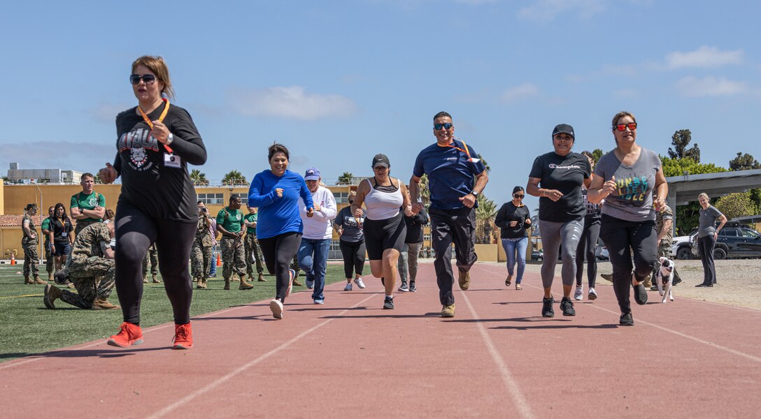 Educators with Recruiting Station Riverside and Recruiting Station San Diego, run on the track during Educators' Workshop at Marine Corps Recruit Depot San Diego, California, July 12, 2022. The Educators' Workshop is a five-day program designed to better inform high school and college teachers, coaches, counselors, and influencers about the benefits and opportunities available during service in the Marine Corps. This allows attendees to return home and provide firsthand experience and knowledge to individuals interested in military service. (U.S. Marine Corps photo by Sgt. Ana S. Madrigal)