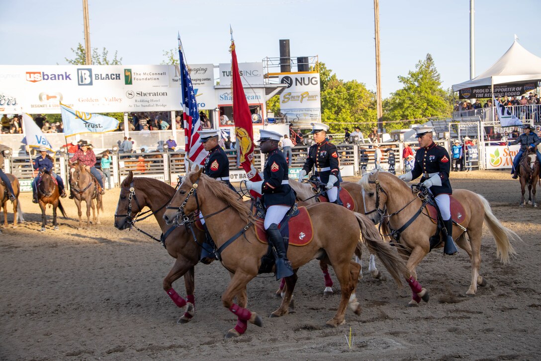 U.S. Marines assigned to the U.S. Marine Corps Mounted Color Guard present the national ensign and organizational colors during the 74th Annual Redding Rodeo in Redding, California on May 19, 2022. The Mounted Color Guard is based out of Marine Corps Logistics Base Barstow, California, and is the only mounted color guard in the Marine Corps. They travel nationwide to perform in parades, ceremonies, and rodeos. (U.S. Marine Corps photo by Cpl. Seaira Moore)